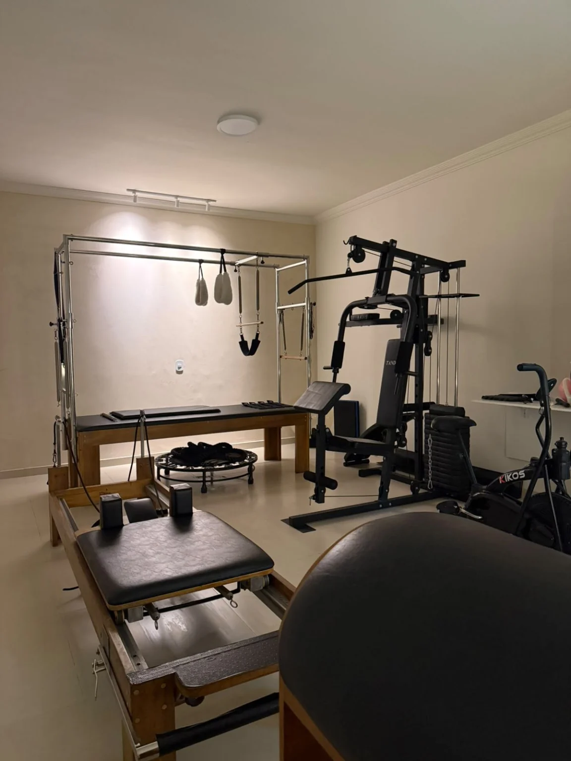 Equipamentos de Pilates e movimento organizados na sala.