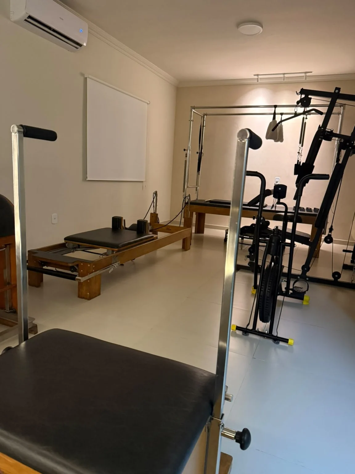 Área para exercícios com equipamentos de Pilates e bicicleta de movimento.